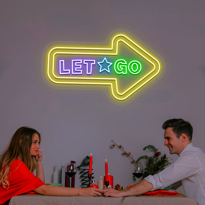 yellow let go arrow vintage neon sign mounted on a wall