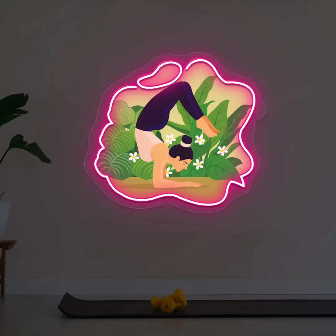 Vrischikasana Garden Yoga Neon Artwork lighting up in pink color in a yoga room