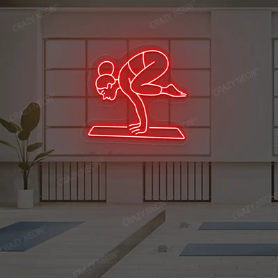 Bakasana Yoga Neon Sign lighting up in red color in a yoga room