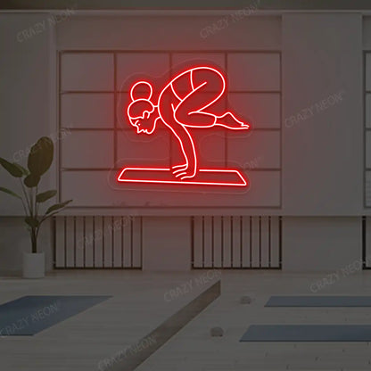 Bakasana Yoga Neon Sign lighting up in red color in a yoga room