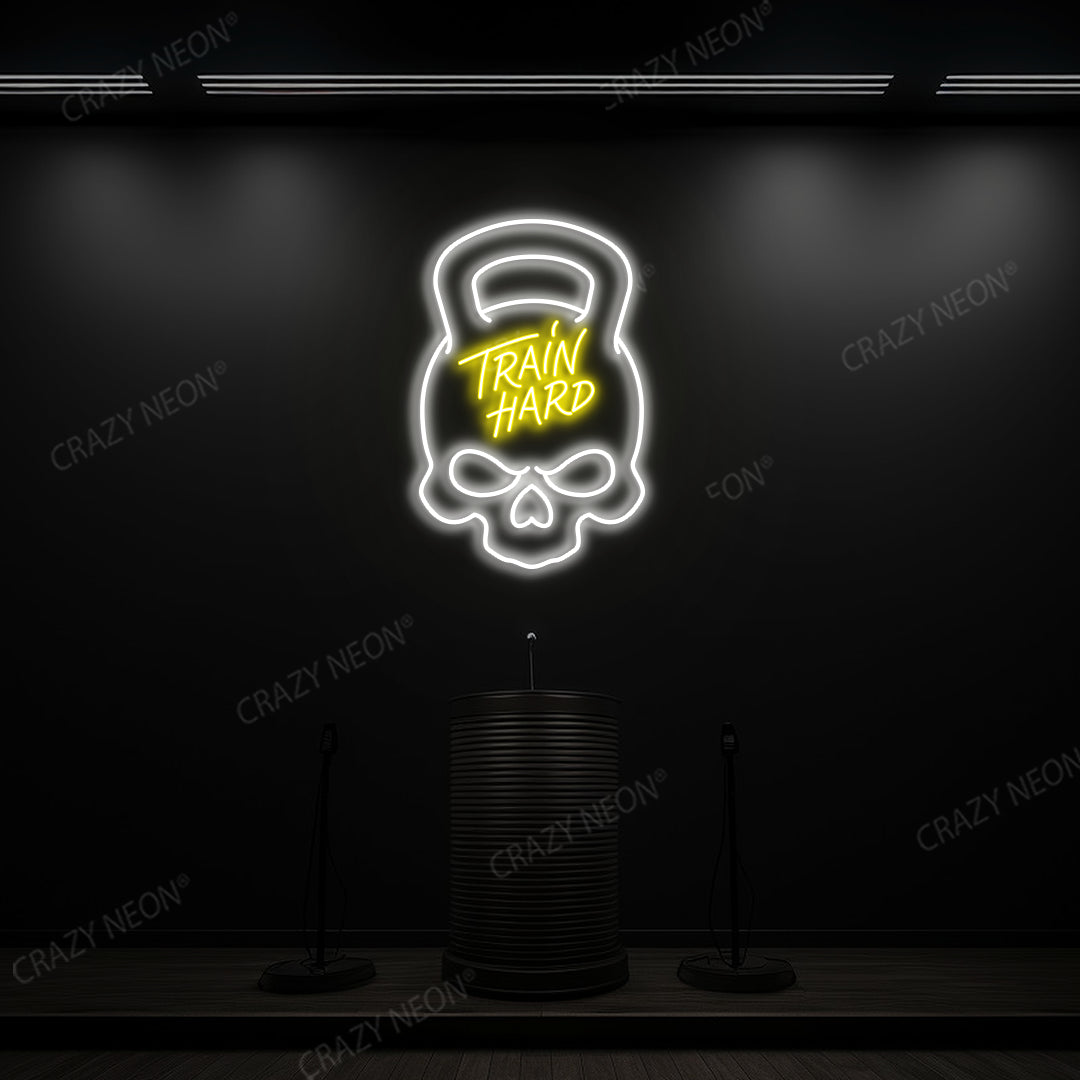 yellow and white train hard kettlebell neon sign mounted on a wall