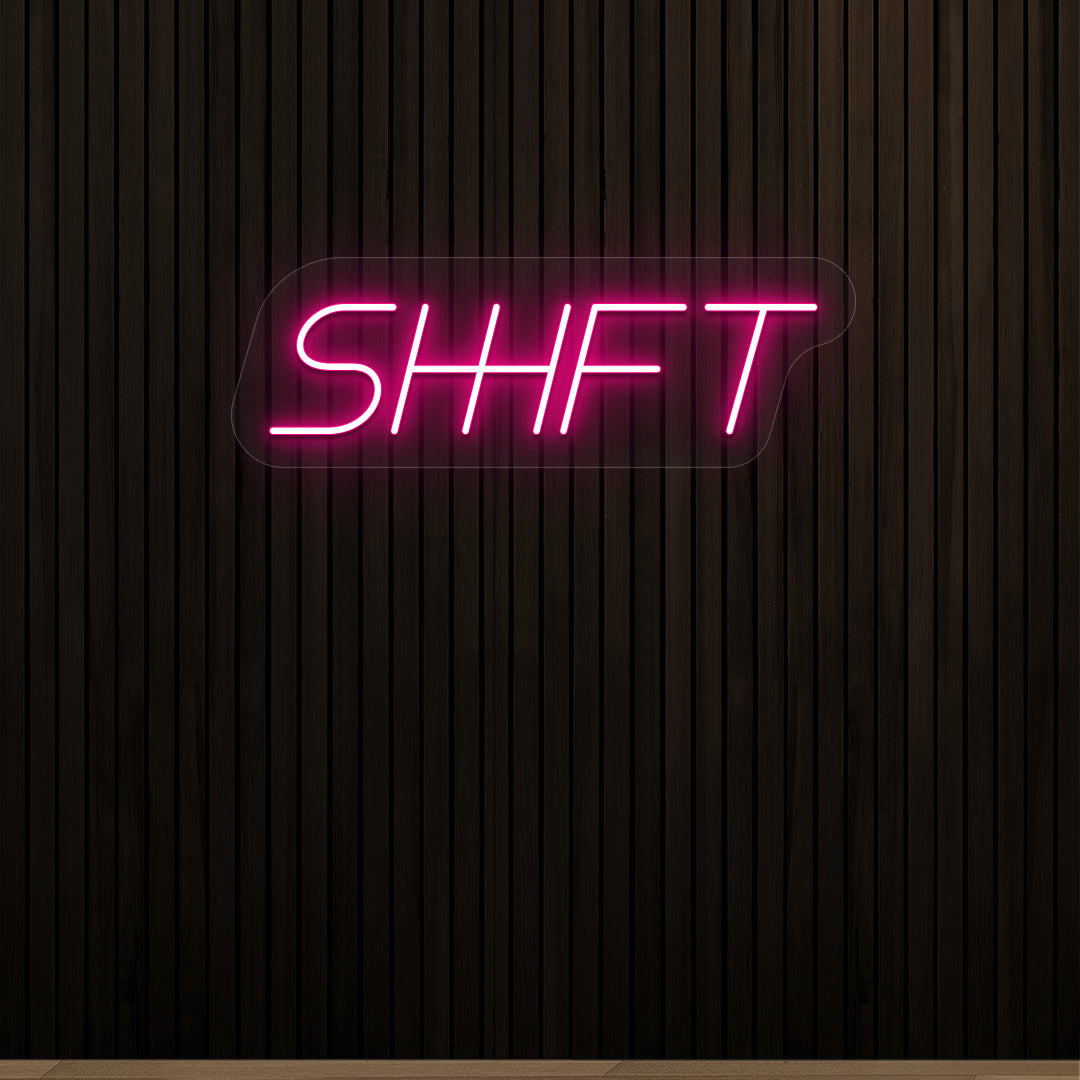 pink shift vintage neon sign mounted on a wall