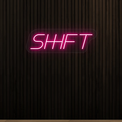 pink shift vintage neon sign mounted on a wall