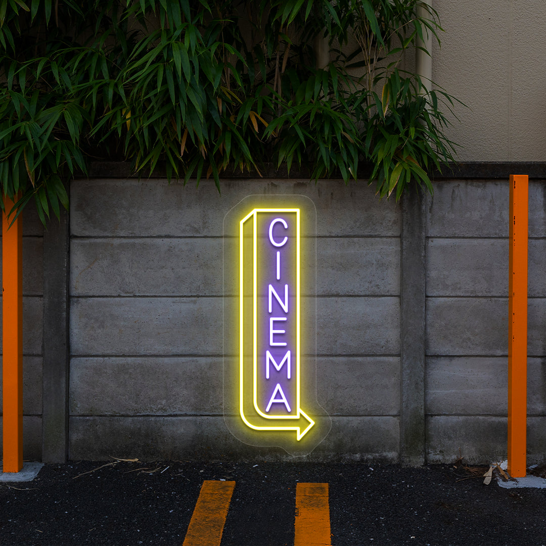 purple and yellow midnight cinema vintage neon sign mounted on a wall