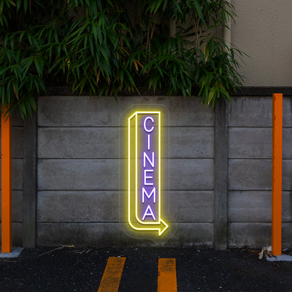 purple and yellow midnight cinema vintage neon sign mounted on a wall