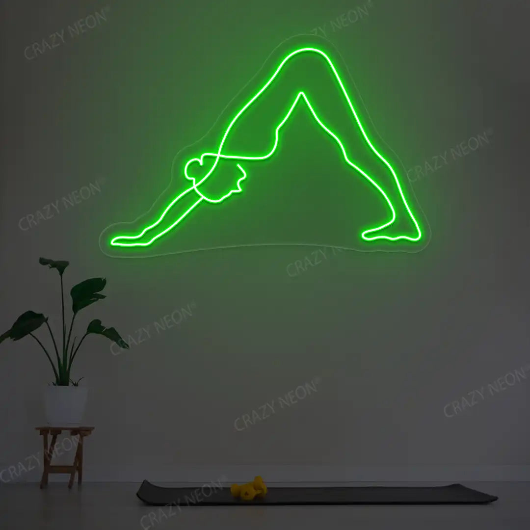 Adho Mukha Svanasana Yoga Neon Sign lighting up in green color in a yoga room