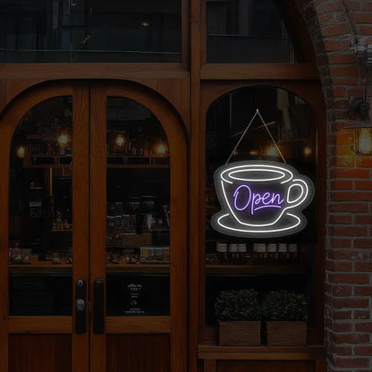 purple coffee open neon sign hanging on a window