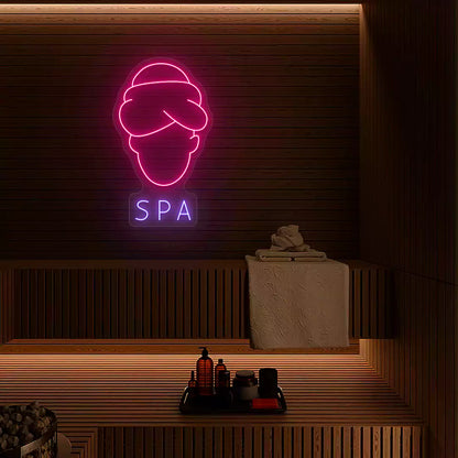 Serenity Face Spa neon sign in pink and purple colors mounted in a spa room