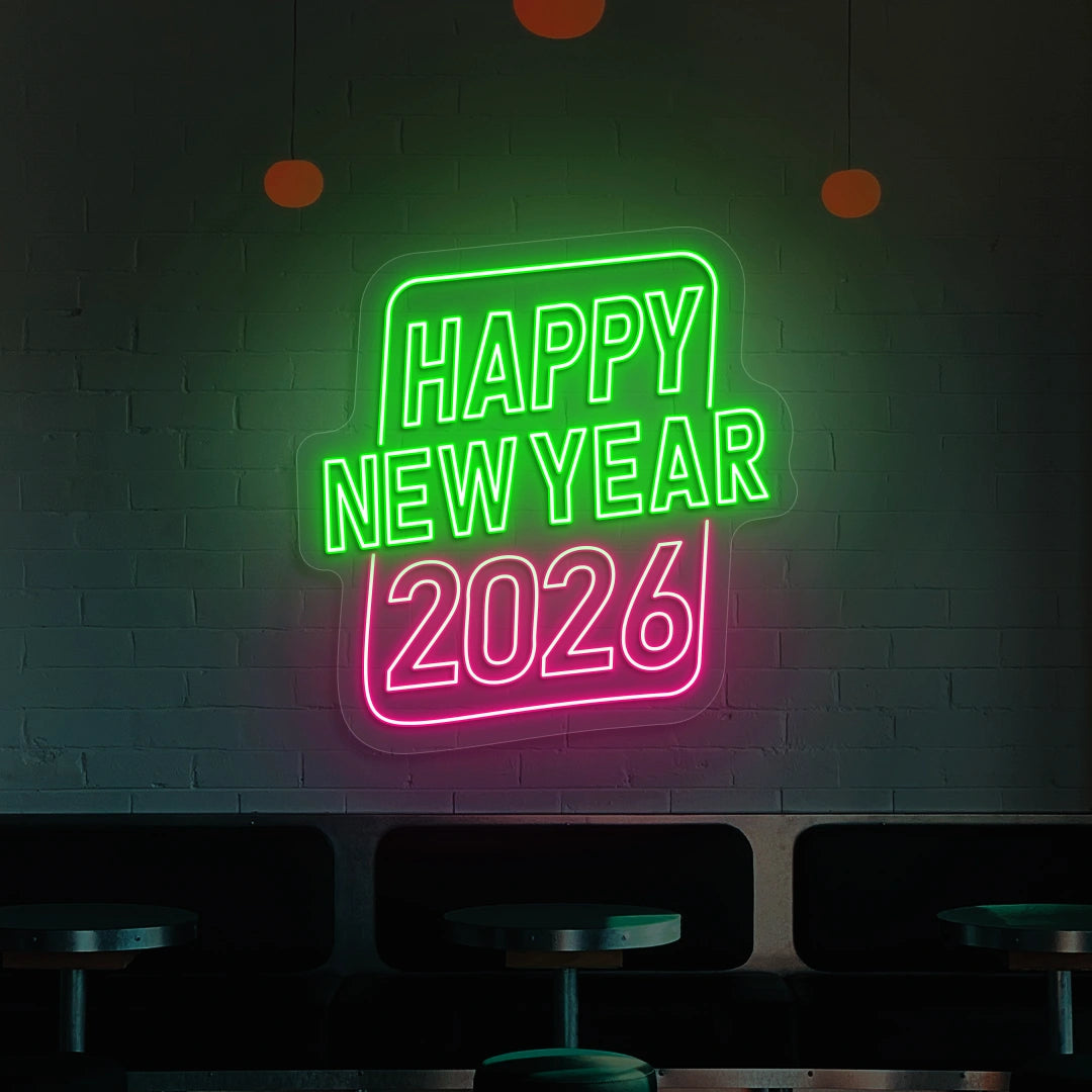 Neon sign reading Happy New Year 2026 in green and pink lights on a brick wall 