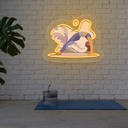 Urdhva Dhanurasana Yoga Neon Artwork lighting up in orange color in a yoga room