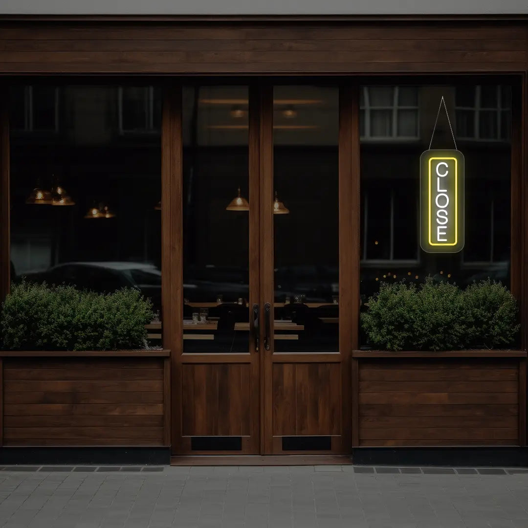 yellow vertical close neon sign hanging on a window