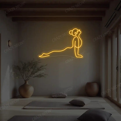 Urdhva Mukha Svanasana Yoga Neon Sign lighting up in orange color in a yoga room