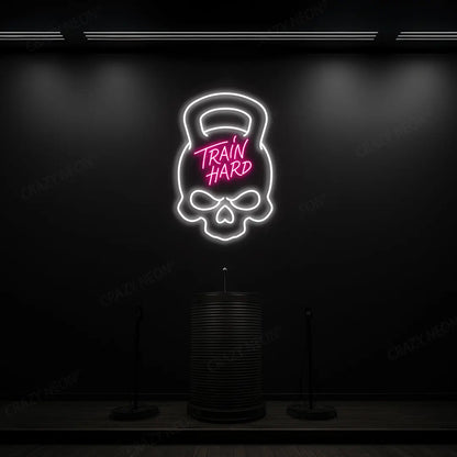 pink and white train hard kettlebell neon sign mounted on a wall