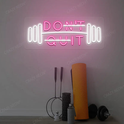 pink and white don’t quit do it neon sign mounted on a wall