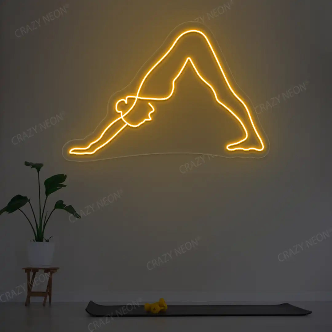 Adho Mukha Svanasana Yoga Neon Sign lighting up in orange color in a yoga room
