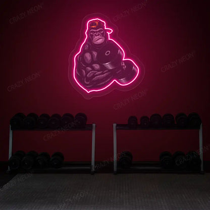 pink gorilla dumbbell lifting gym neon artwork mounted on a wall