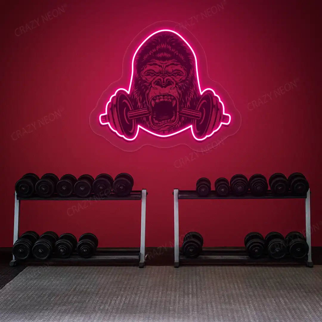 pink gorilla barbell gym neon artwork mounted on a wall
