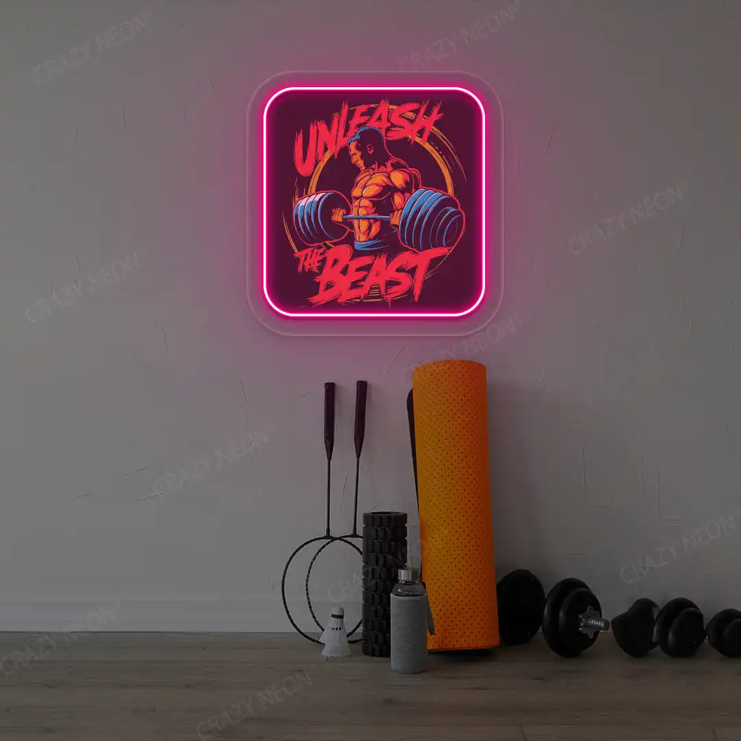 pink unleash the beast gym neon artwork mounted on a wall