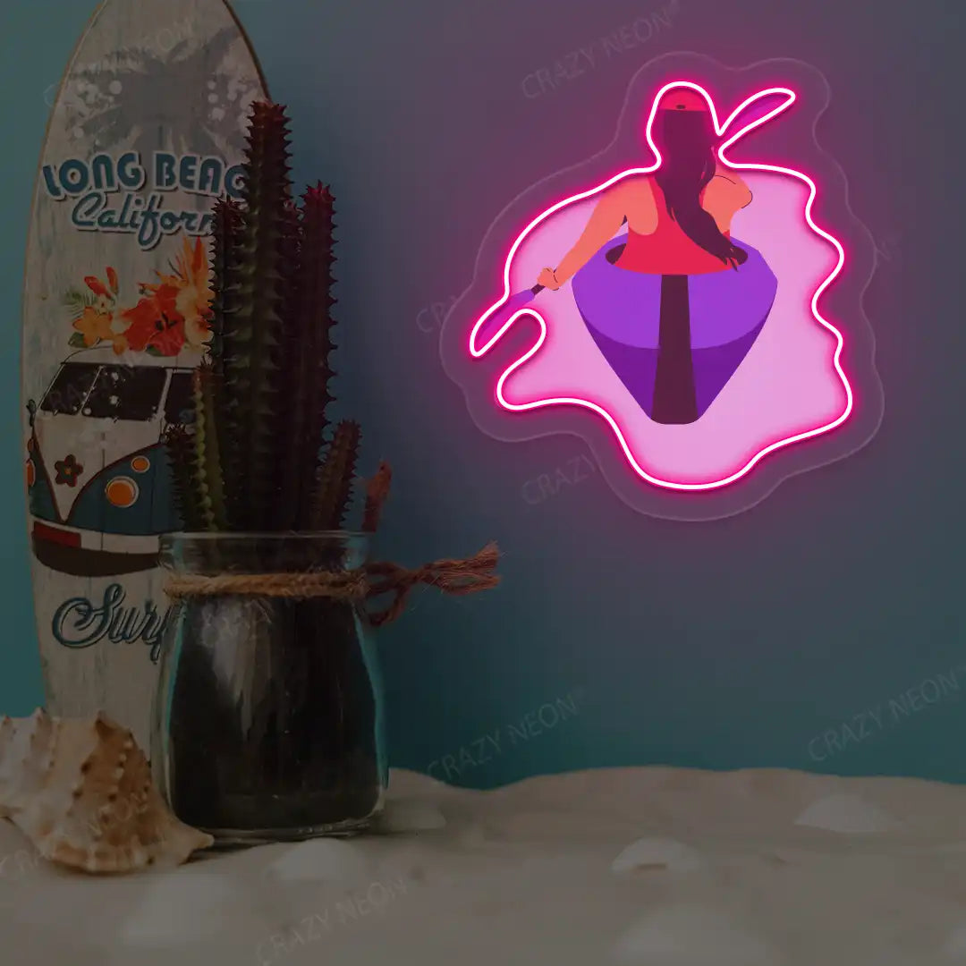 pink woman kayaking neon artwork mounted on a wall