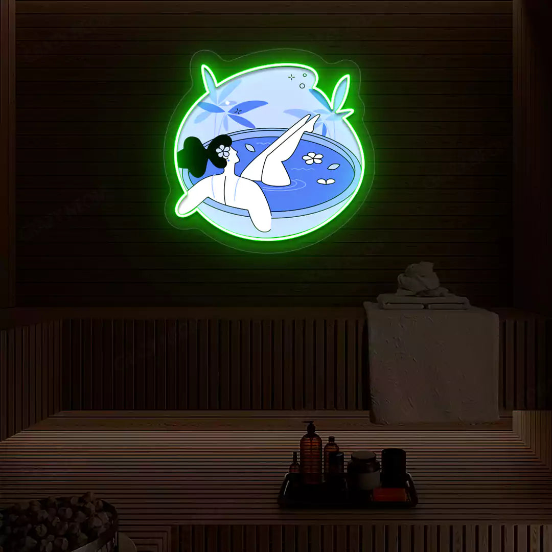 Blue Blossom Bath Neon Artwork lighting up in green color on a wooden spa wall