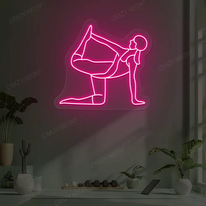 Ardha Dhanurasana Yoga Neon Sign glowing in pink color in a yoga room