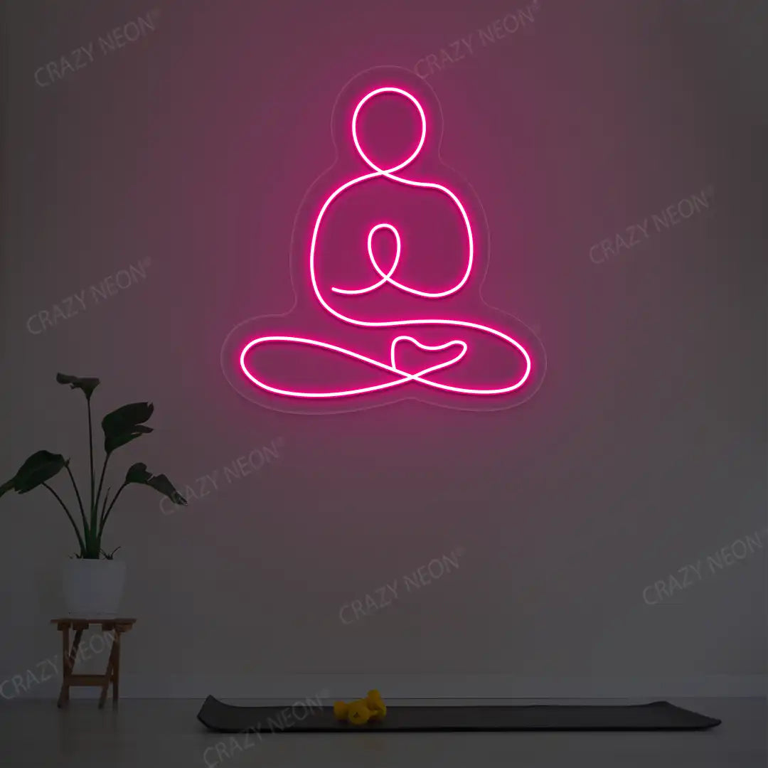 Swastikasana Yoga Neon Sign lighting up in pink color in a yoga room