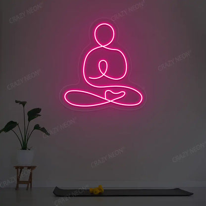 Swastikasana Yoga Neon Sign lighting up in pink color in a yoga room