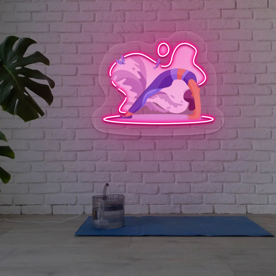 Urdhva Dhanurasana Yoga Neon Artwork lighting up in pink color in a yoga room