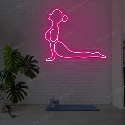 Bhujangasana Yoga Neon Sign glowing in pink color in a yoga room
