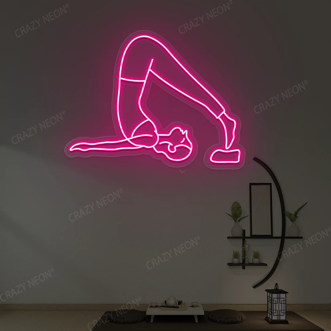 Halasana Yoga Neon Sign glowing in pink color in a yoga room