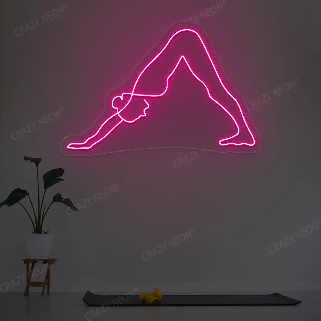 Adho Mukha Svanasana Yoga Neon Sign lighting up in pink color in a yoga room