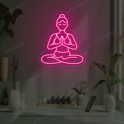 Padmasana Anjali Mudra Yoga Neon Sign lighting up in pink color in a yoga room