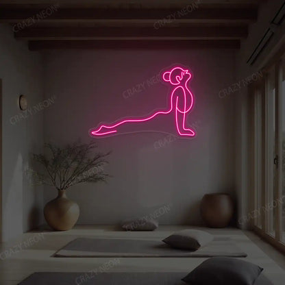 Urdhva Mukha Svanasana Yoga Neon Sign lighting up in pink color in a yoga room