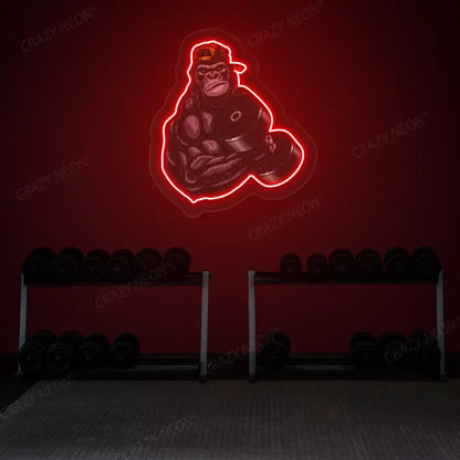 red gorilla dumbbell lifting gym neon artwork mounted on a wall