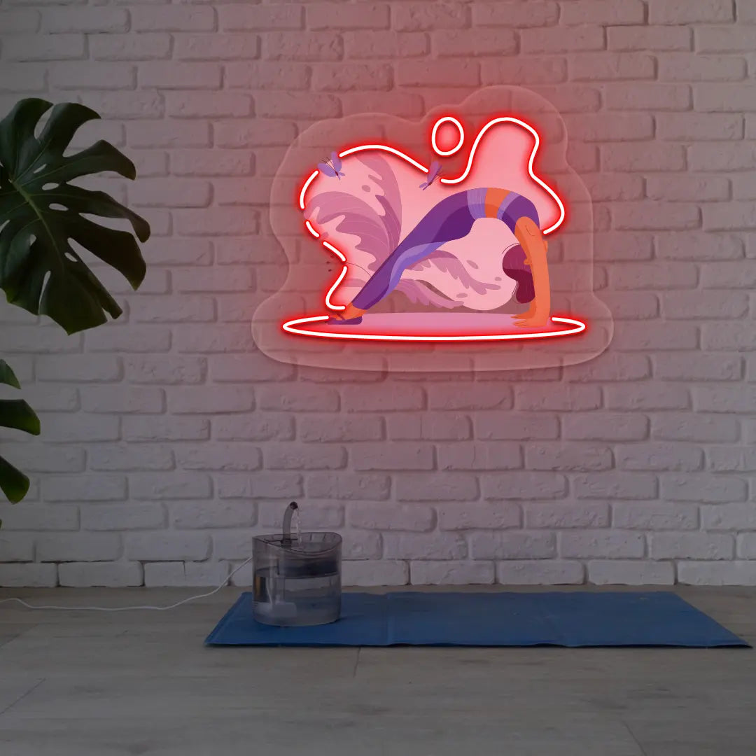 Urdhva Dhanurasana Yoga Neon Artwork lighting up in red color in a yoga room