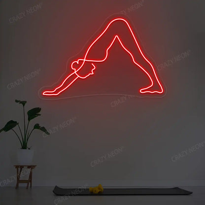 Adho Mukha Svanasana Yoga Neon Sign lighting up in red color in a yoga room