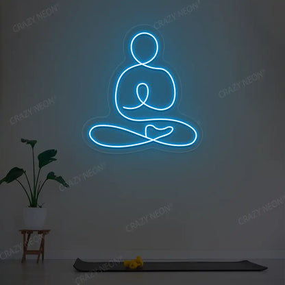 Swastikasana Yoga Neon Sign lighting up in ice blue color in a yoga room