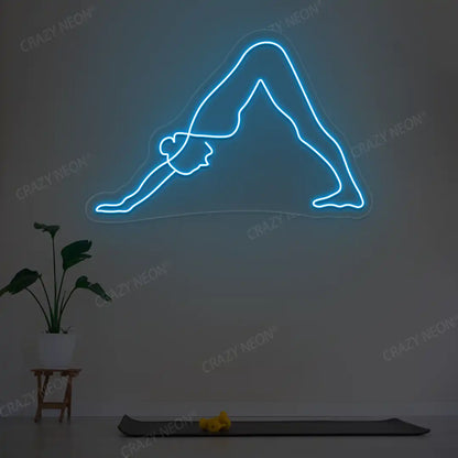 Adho Mukha Svanasana Yoga Neon Sign lighting up in ice blue color in a yoga room