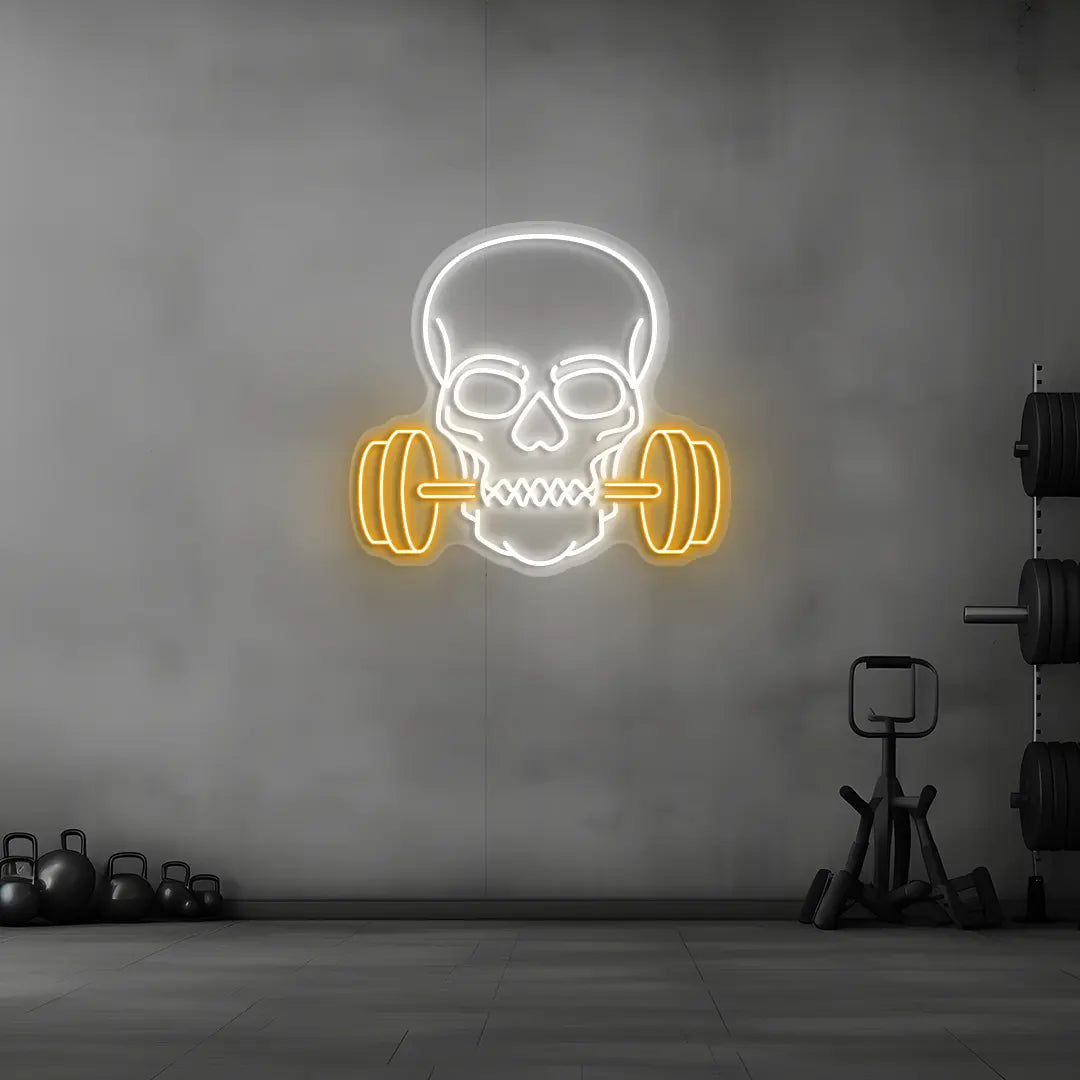orange and white skull barbell gym neon sign mounted on a wall