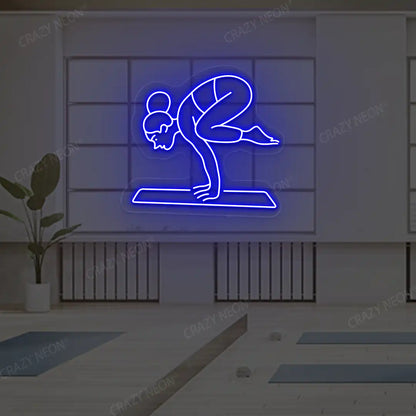 Bakasana Yoga Neon Sign lighting up in blue color in a yoga room