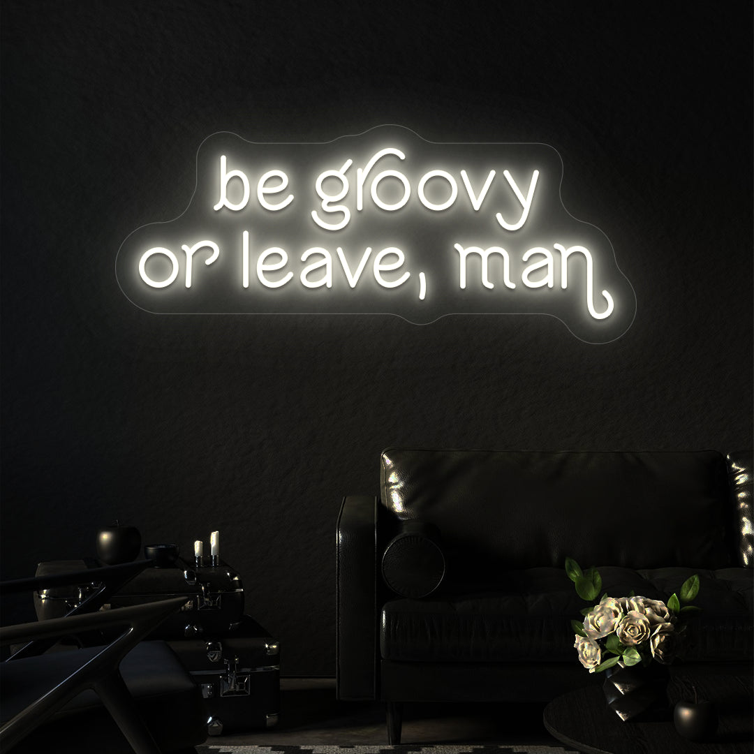 warm white be groovy or leave, man vintage neon sign mounted on a wall