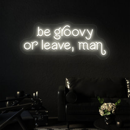 warm white be groovy or leave, man vintage neon sign mounted on a wall
