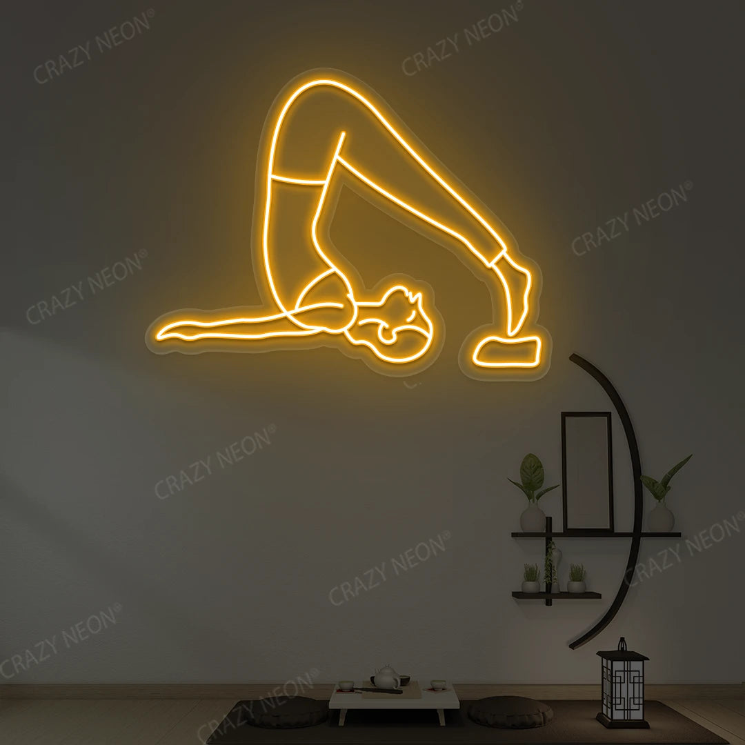 Halasana Yoga Neon Sign glowing in orange color in a yoga room