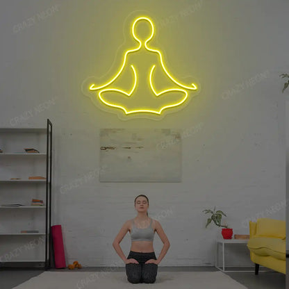 Sukhasana Yoga Neon Sign lighting up in yellow color in a yoga room