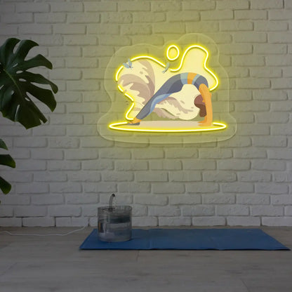 Urdhva Dhanurasana Yoga Neon Artwork lighting up in yellow color in a yoga room