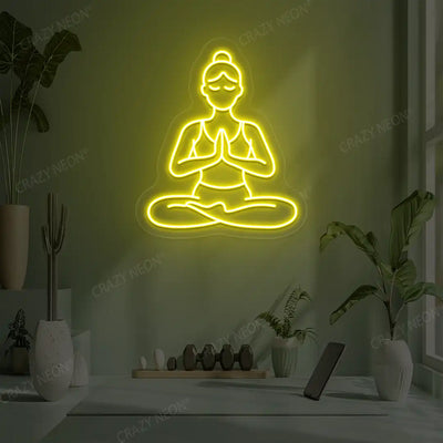 Padmasana Anjali Mudra Yoga Neon Sign lighting up in yellow color in a yoga room
