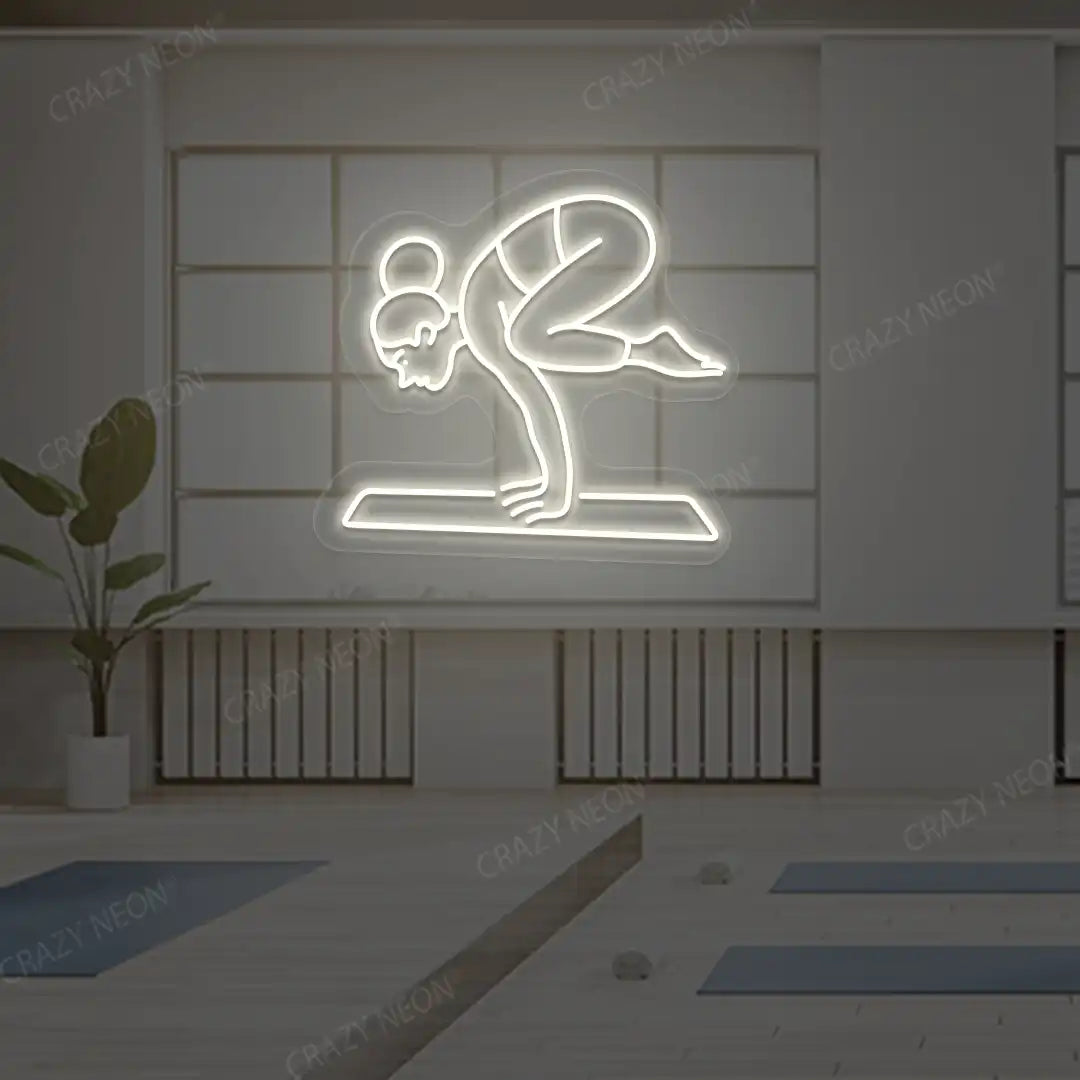 Bakasana Yoga Neon Sign lighting up in warm white color in a yoga room
