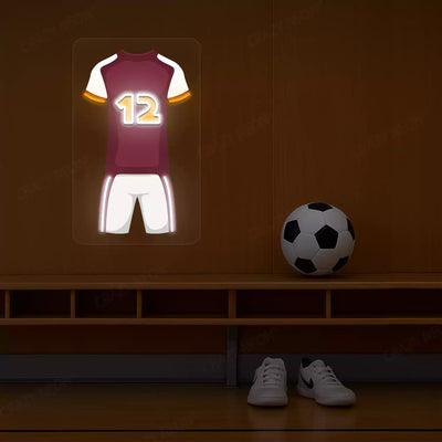 Maroon football jersey neon artwork with number 12 glowing on a wooden wall