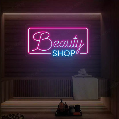Pink and ice blue Beauty Shop neon sign glowing on a wooden wall