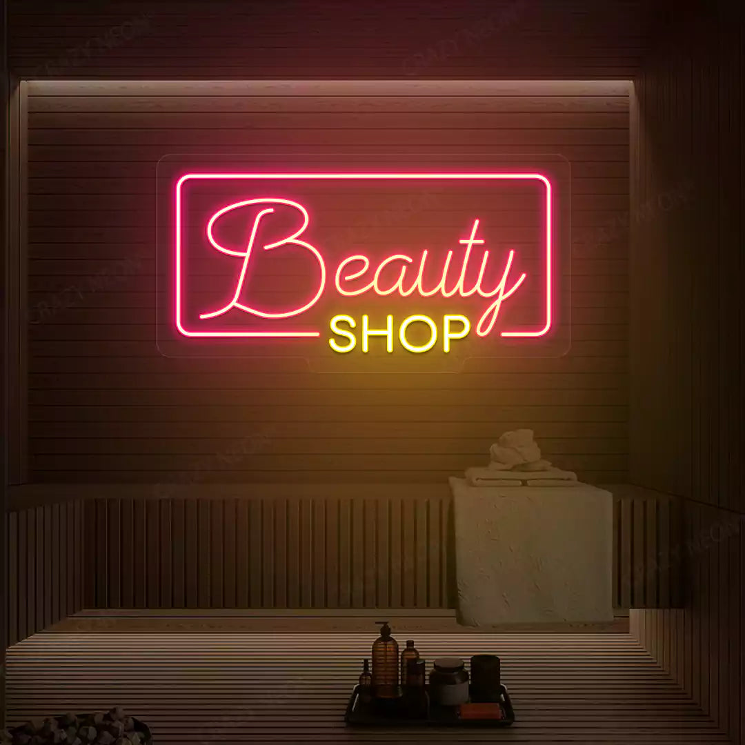 Pink and yellow Beauty Shop neon sign glowing on a wooden wall